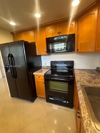 a kitchen with stainless steel appliances a stove a microwave and a hard wood floor