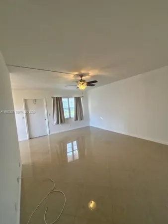 a view of a livingroom with a ceiling fan and window