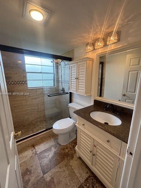 305 Preston F, Unit H Boca Raton, FL 33434 - Photo 8 of 17 a bathroom with a granite countertop toilet sink and mirror