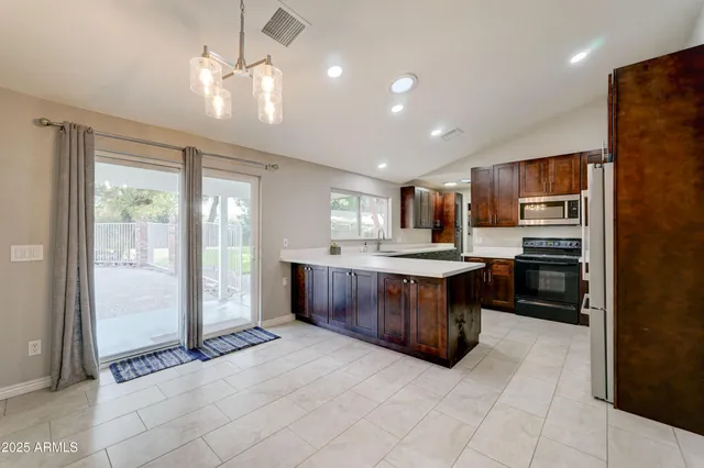 a large kitchen with a large counter top stainless steel appliances and cabinets