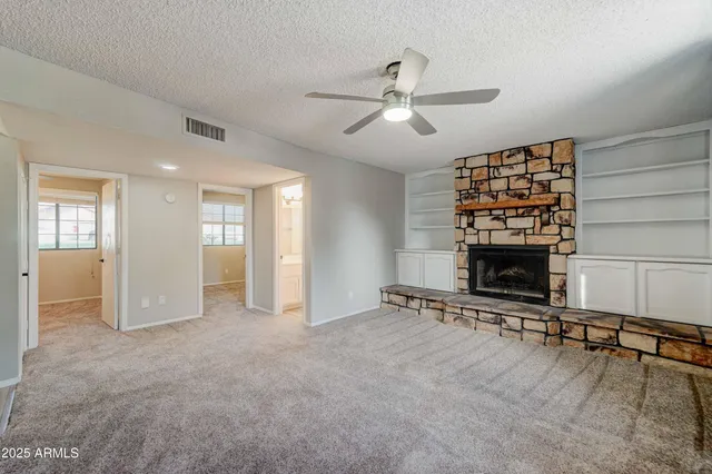 a view of an empty room with a fireplace and a window