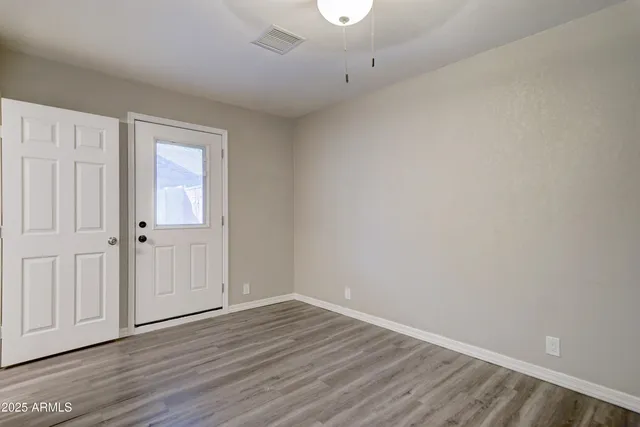a view of an empty room with wooden floor
