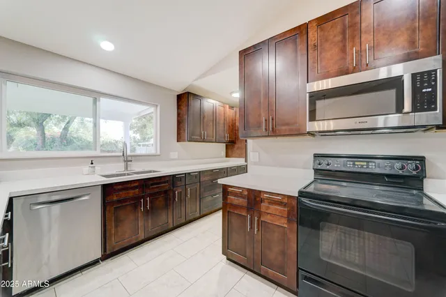 a kitchen with stainless steel appliances granite countertop wooden cabinets and a stove top oven