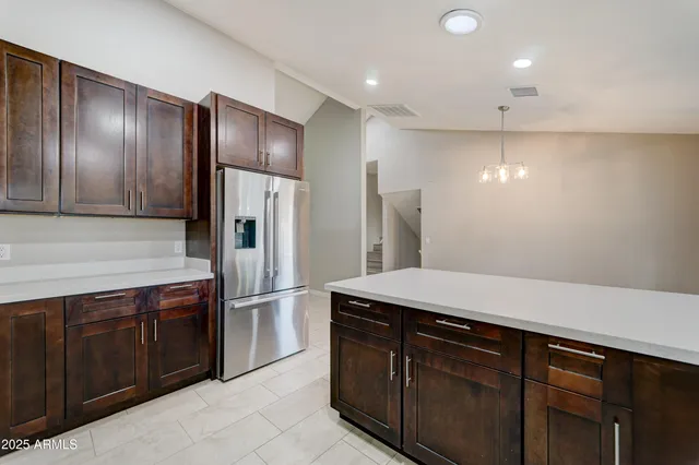 a kitchen with stainless steel appliances granite countertop cabinets and refrigerator