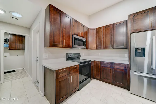 a kitchen with stainless steel appliances granite countertop a stove a refrigerator and a microwave