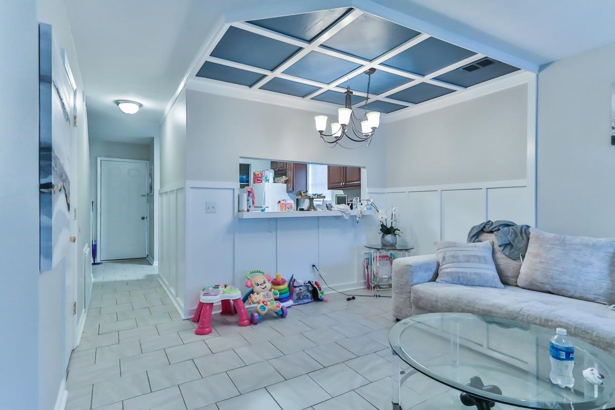 205 Plantation Road Myrtle Beach, SC 29588 - Photo 16 of 35 Tiled living room featuring an inviting chandelier
