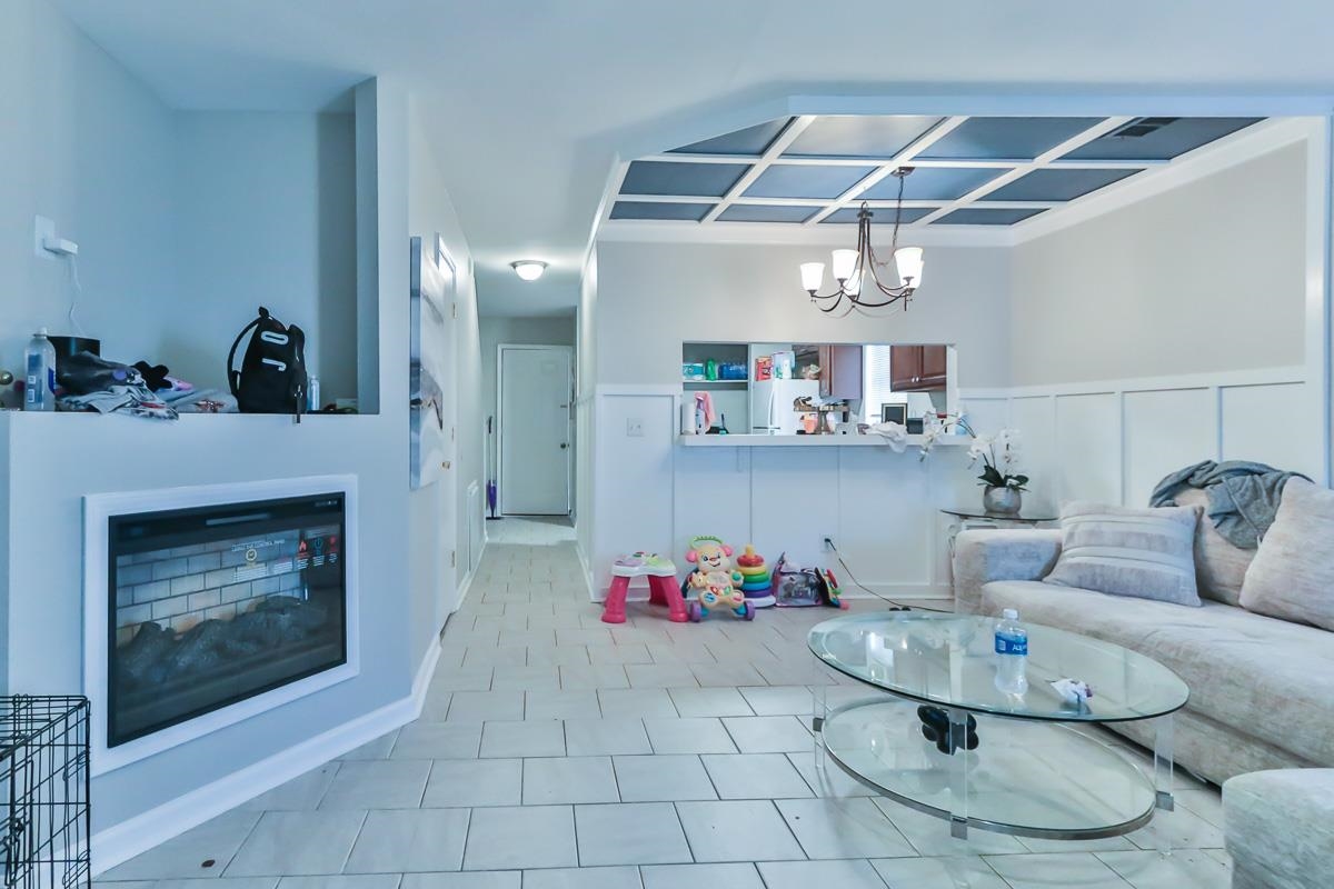 205 Plantation Road Myrtle Beach, SC 29588 - Photo 17 of 35 Tiled living room featuring a chandelier