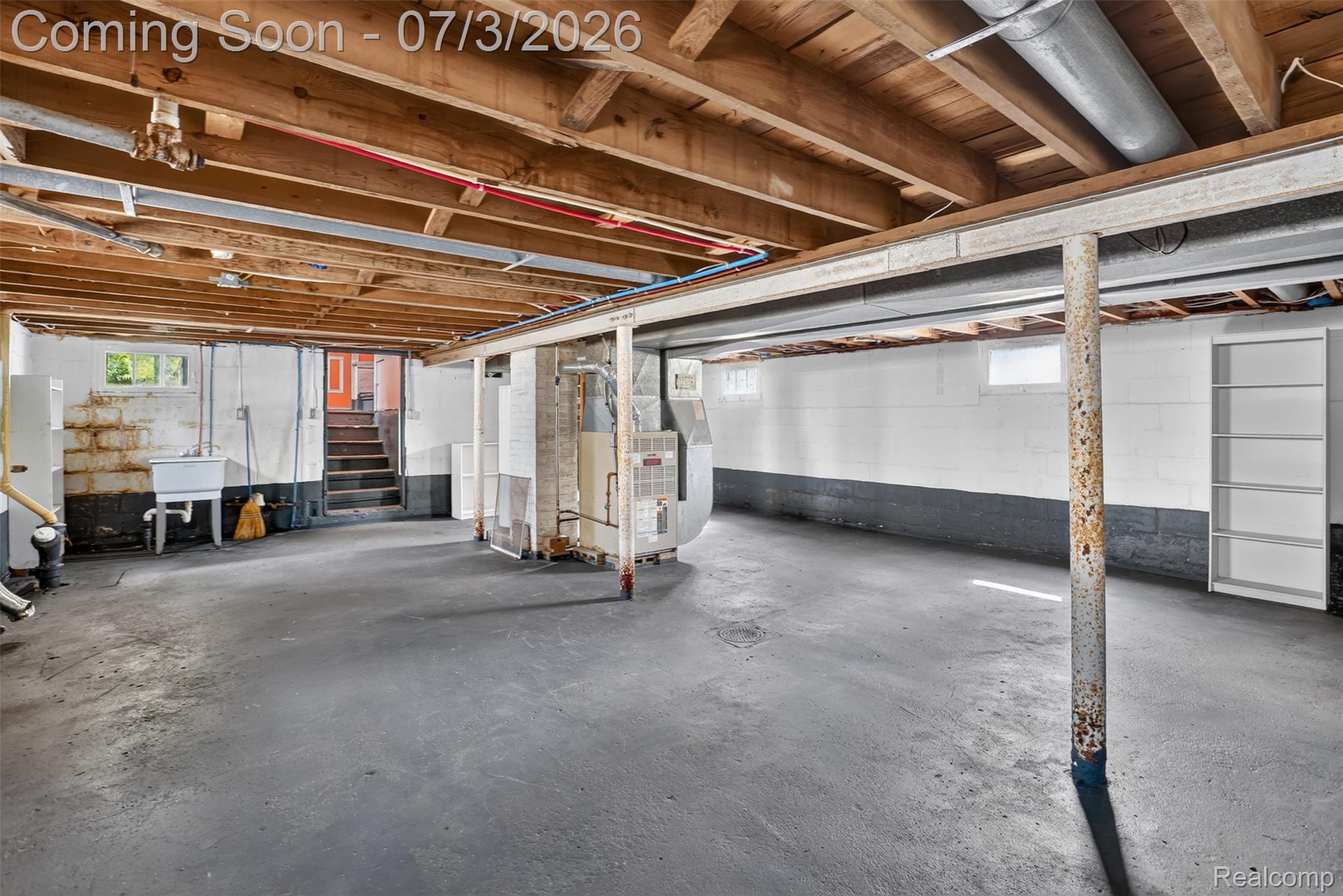 4322 Baker Road Bridgeport, MI 48722 - Photo 21 of 29 Expansive unfinished basement featuring a concrete floor, exposed wood ceiling joists, and white painted block walls