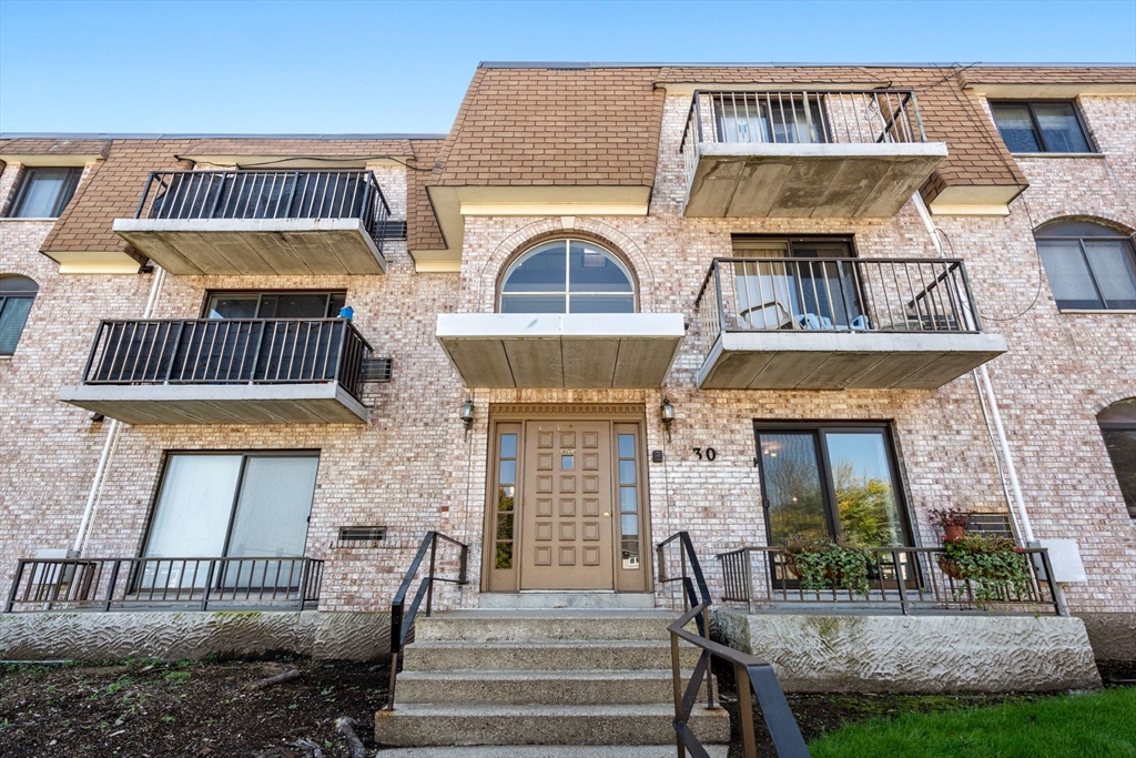 30 High Street, Unit 101 Dedham, MA 02026 - Photo 1 of 36 a front view of a house with a garden