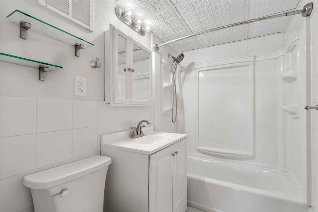 30 High Street, Unit 101 Dedham, MA 02026 - Photo 11 of 36 a bathroom with a sink toilet and shower