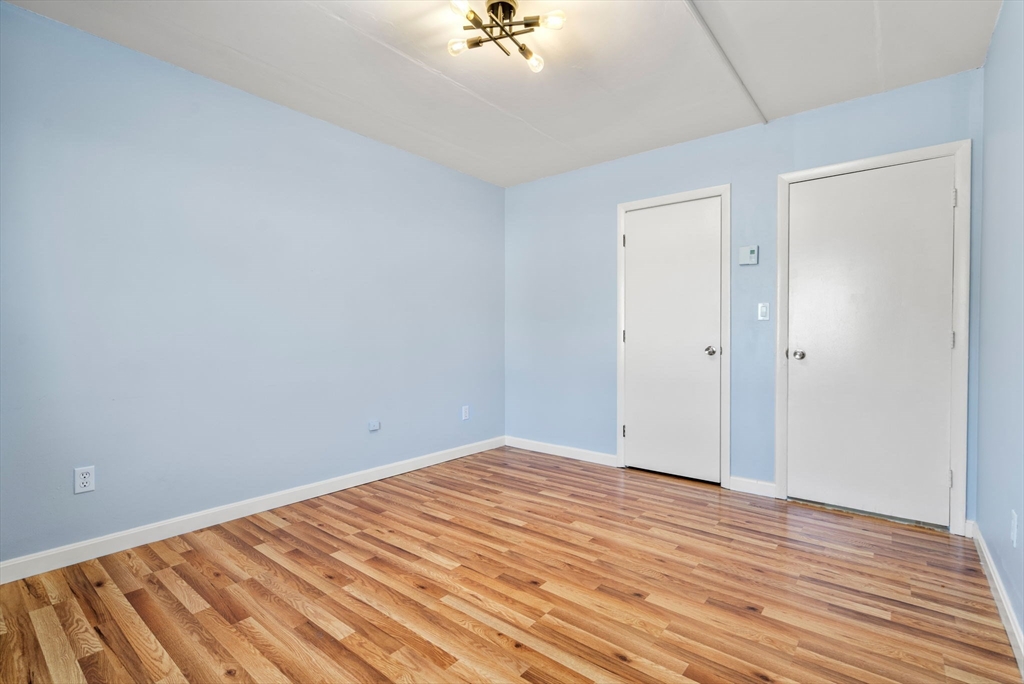 30 High Street, Unit 101 Dedham, MA 02026 - Photo 15 of 36 an empty room with wooden floor and a ceiling fan