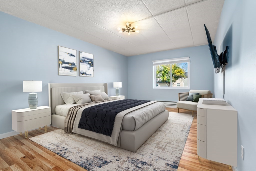 30 High Street, Unit 101 Dedham, MA 02026 - Photo 16 of 36 a bedroom with a large bed and a flat screen tv