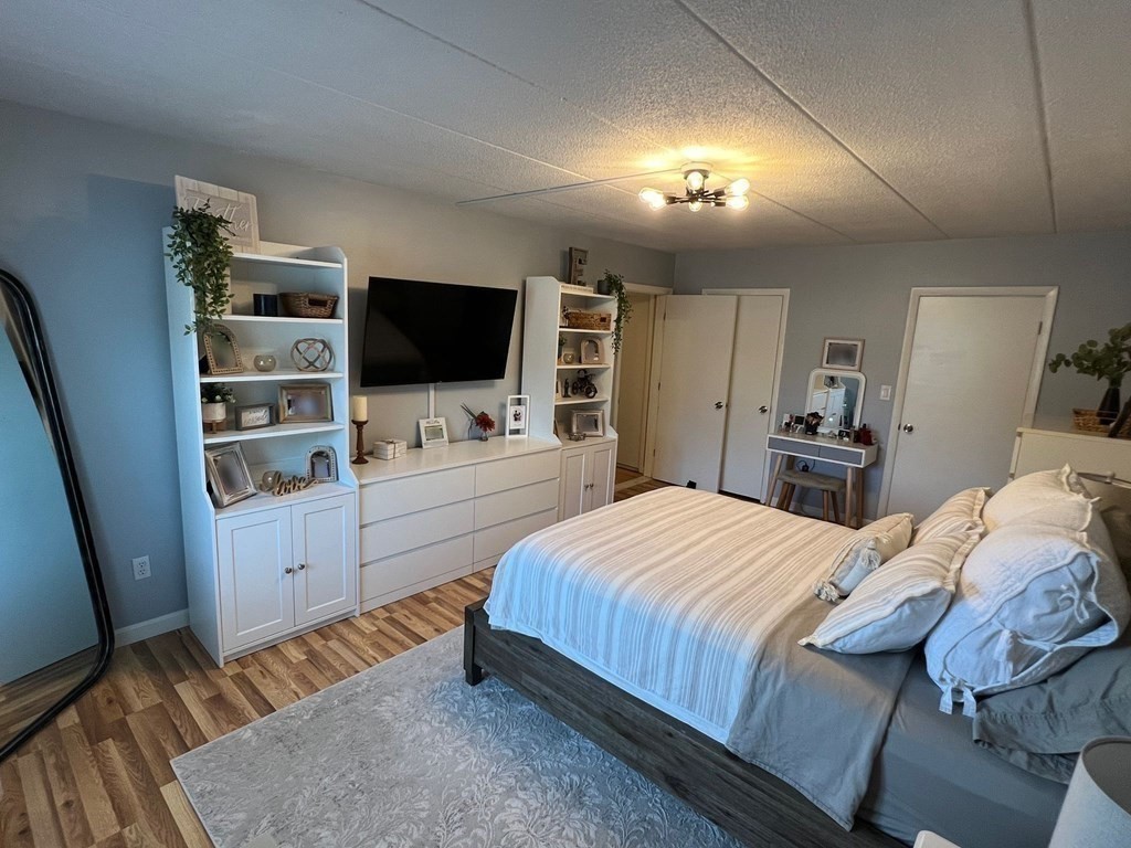 30 High Street, Unit 101 Dedham, MA 02026 - Photo 24 of 36 a bedroom with a bed and a flat screen tv