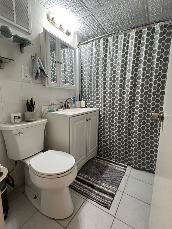 30 High Street, Unit 101 Dedham, MA 02026 - Photo 26 of 36 a bathroom with a toilet and a shower curtain