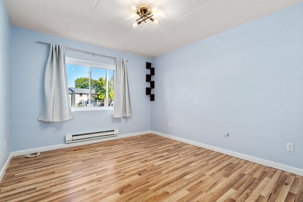 30 High Street, Unit 101 Dedham, MA 02026 - Photo 29 of 36 a view of an empty room with a window and wooden floor