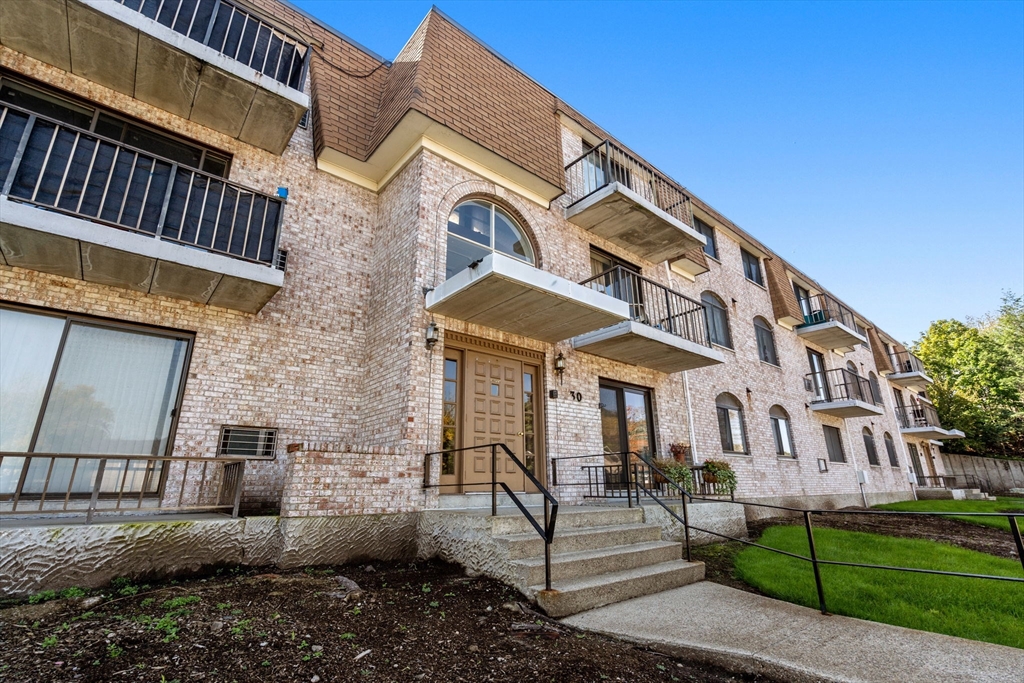 30 High Street, Unit 101 Dedham, MA 02026 - Photo 32 of 36 a front view of a house with a yard