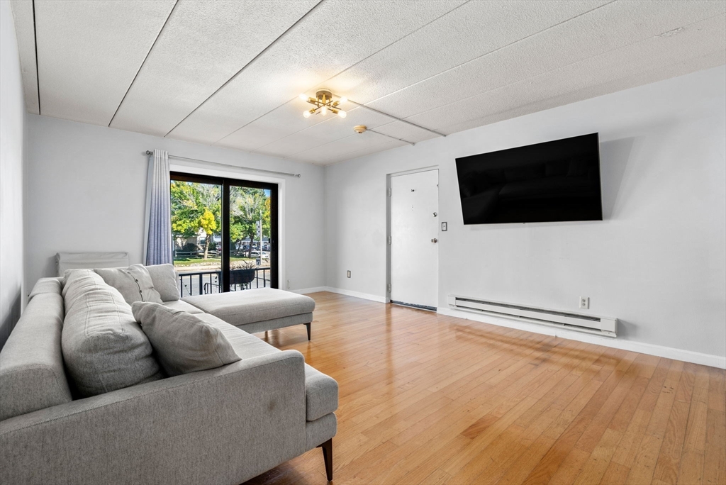 30 High Street, Unit 101 Dedham, MA 02026 - Photo 5 of 36 a living room with furniture and a flat screen tv