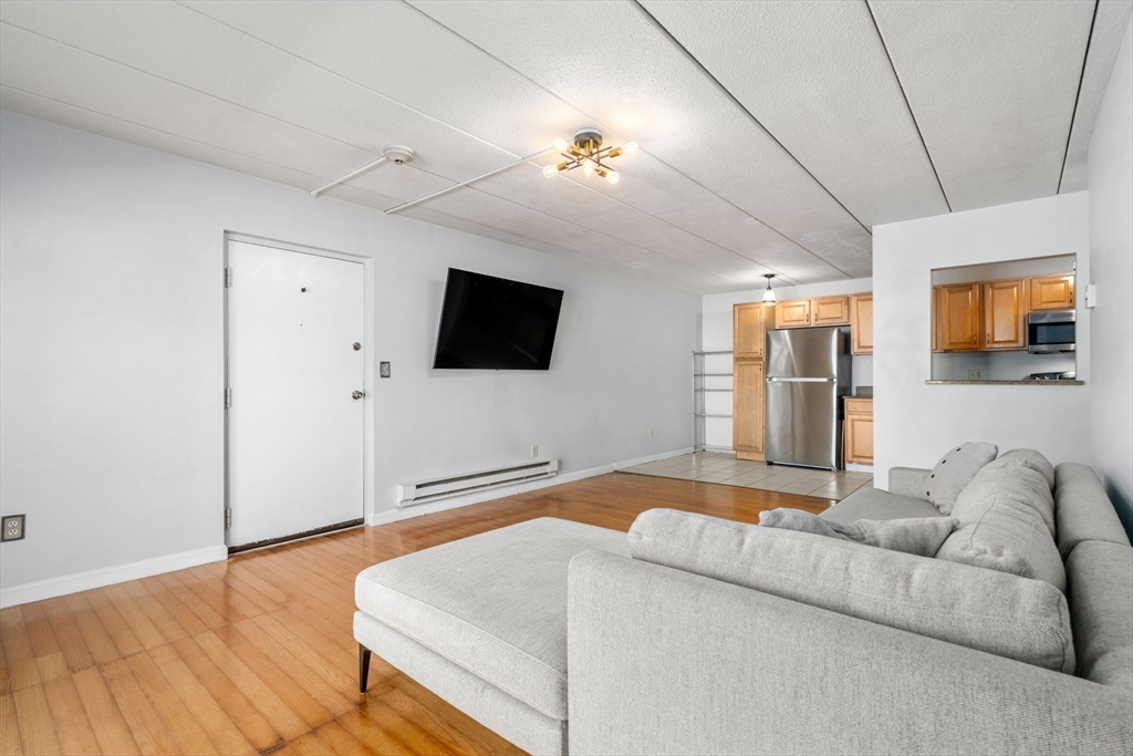 30 High Street, Unit 101 Dedham, MA 02026 - Photo 7 of 36 a living room with furniture and a flat screen tv