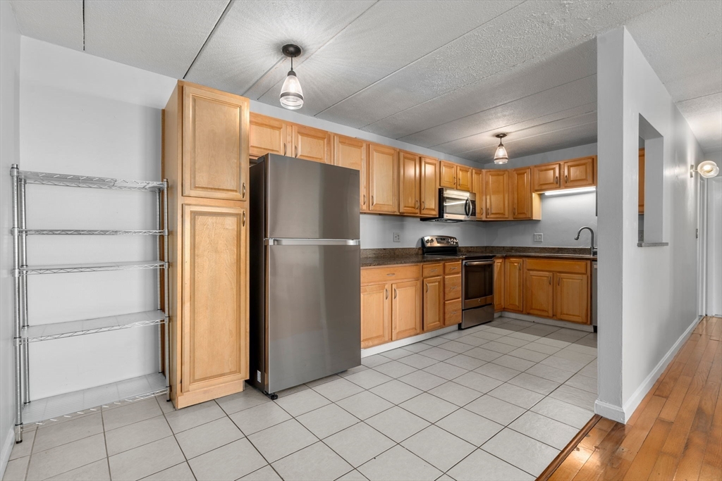 30 High Street, Unit 101 Dedham, MA 02026 - Photo 10 of 36 a kitchen with cabinets a refrigerator and a sink
