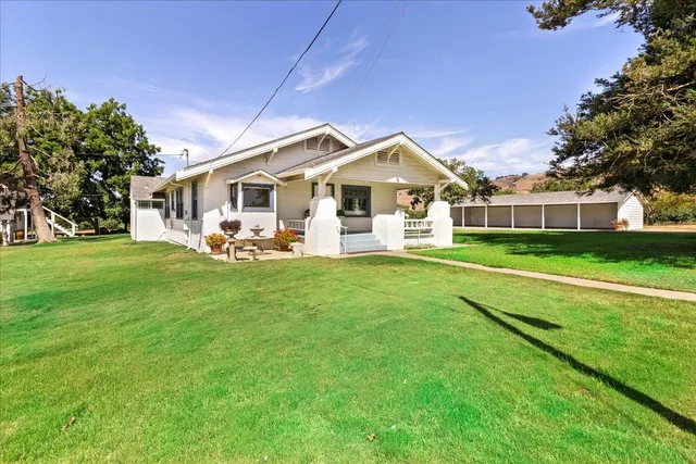 a front view of a house with a garden and trees