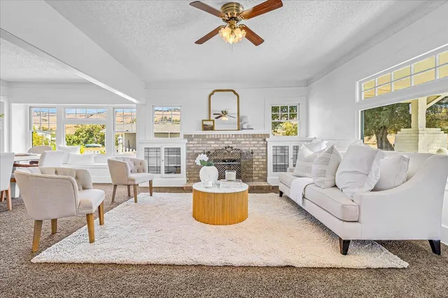 a view of a dining room with furniture a chandelier and a window
