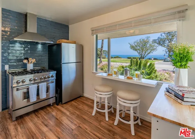 a kitchen with stainless steel appliances a stove a refrigerator and a table