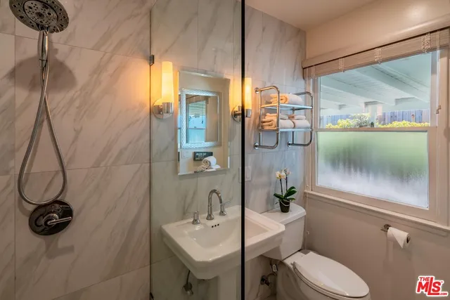 a bathroom with a sink a toilet and shower