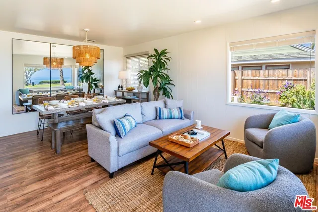 a living room with furniture a table and a large window