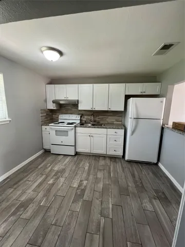 a kitchen with wooden cabinets and white appliances