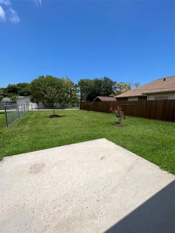 a view of a backyard with potted plants and wooden fence