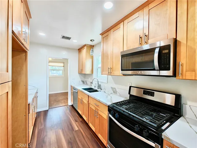 a kitchen with stainless steel appliances granite countertop a sink and a stove