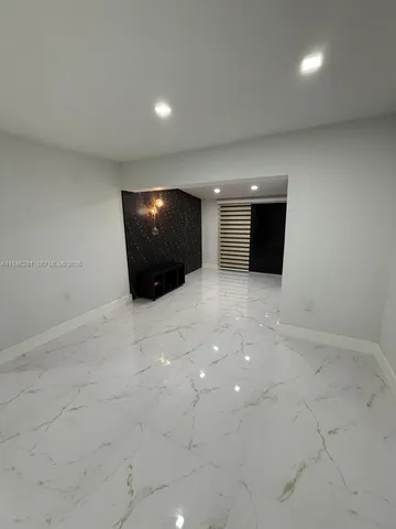 an empty room with white walls and tiles