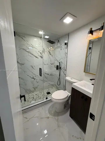 a bathroom with a toilet and a shower