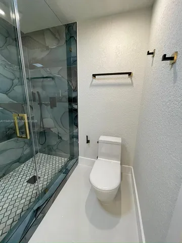 a bathroom with a toilet and a shower