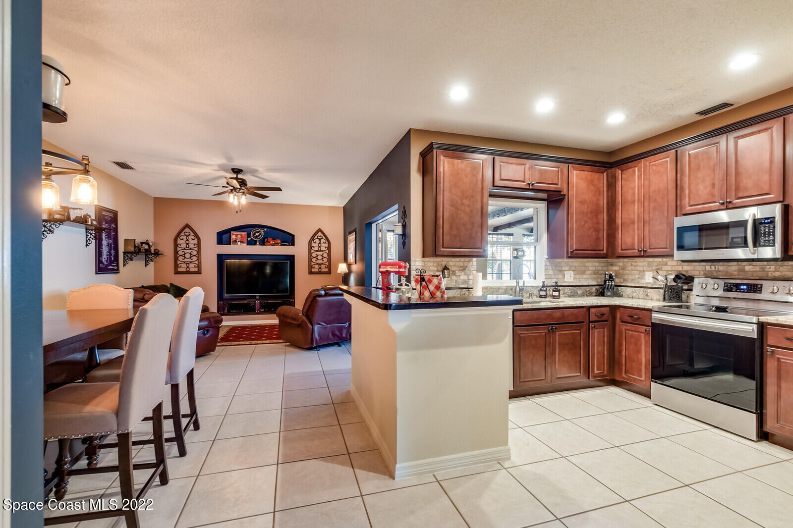 1936 Blue Ridge Avenue Melbourne, FL 32935 - Photo 16 of 35 a kitchen with stainless steel appliances kitchen island granite countertop a refrigerator and a stove top oven