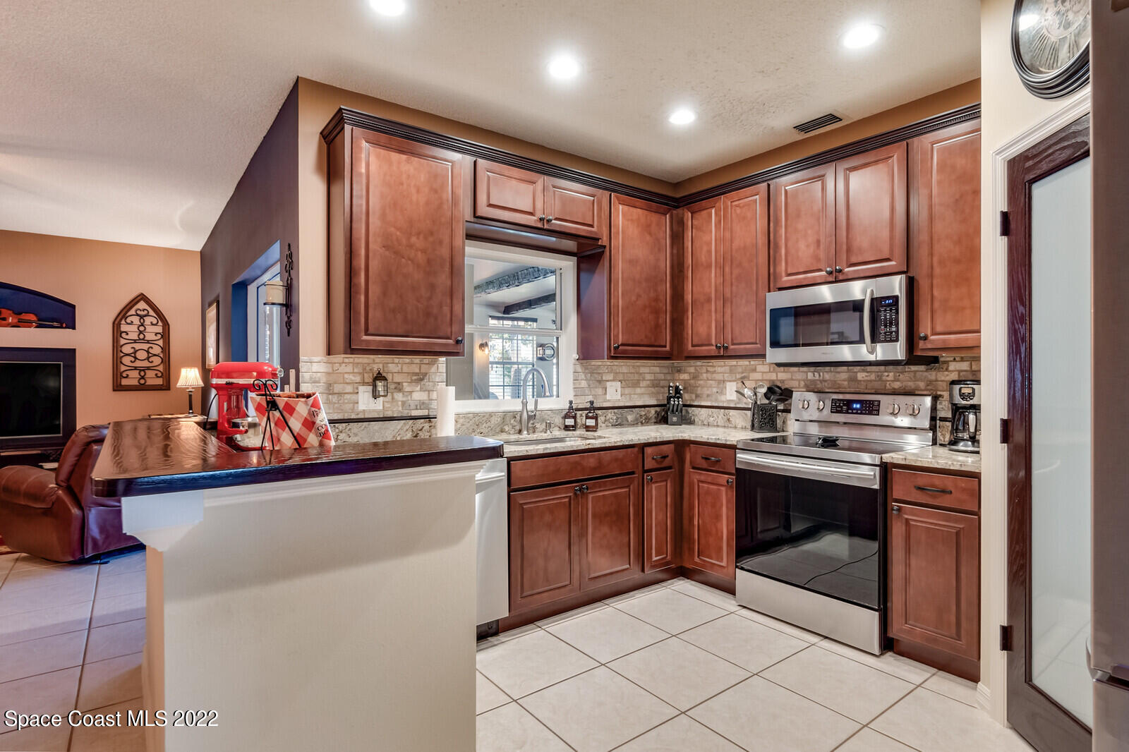 1936 Blue Ridge Avenue Melbourne, FL 32935 - Photo 17 of 35 a kitchen with stainless steel appliances granite countertop a stove sink microwave and cabinets
