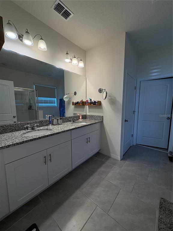 1948 Rankin Street Kissimmee, FL 34744 - Photo 15 of 37 a spacious bathroom with a granite countertop sink a mirror and a vanity