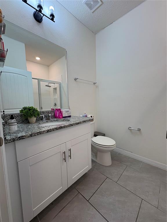 1948 Rankin Street Kissimmee, FL 34744 - Photo 32 of 37 a bathroom with a granite countertop sink a toilet and a mirror