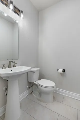 a bathroom with a sink toilet and a mirror