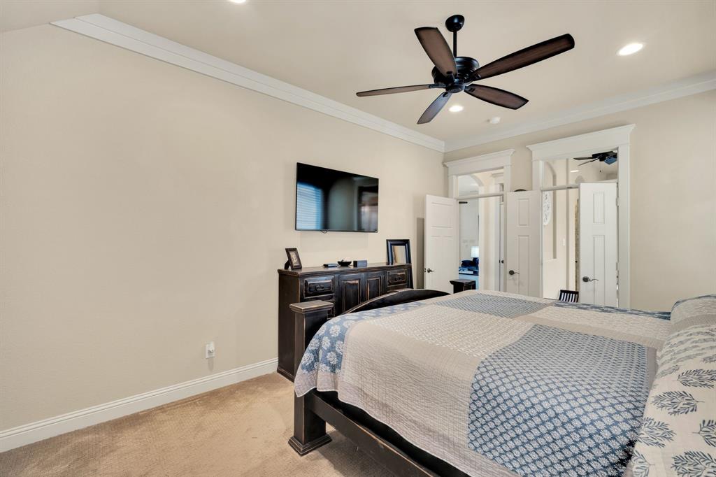 409 George Hopper Road Midlothian, TX 76065 - Photo 11 of 26 a bedroom with a bed a flat screen tv and a ceiling fan