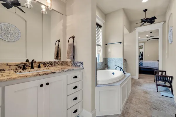 a spacious bathroom with a double vanity sink a mirror a bathtub and shower