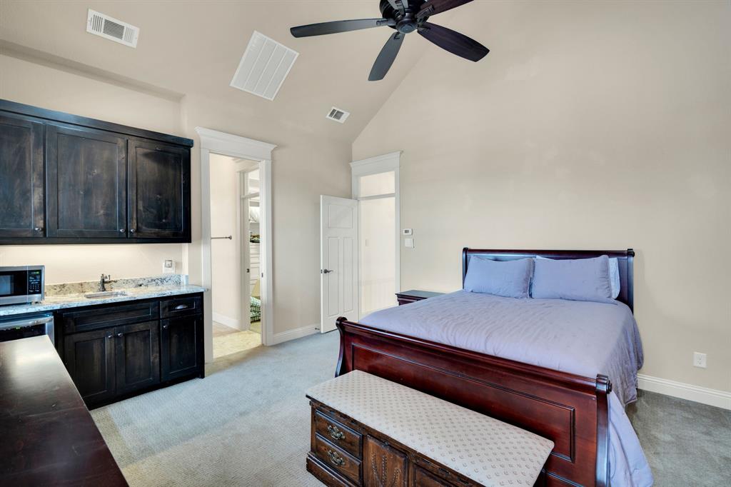 409 George Hopper Road Midlothian, TX 76065 - Photo 21 of 26 a bedroom with a bed and a chandelier