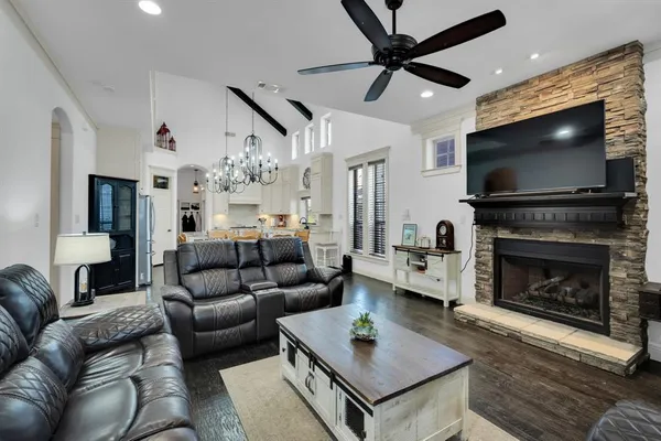 a living room with furniture a flat screen tv and a fireplace