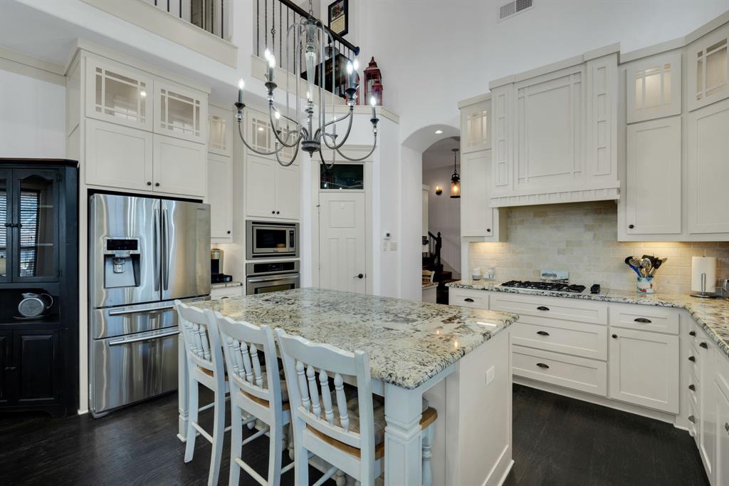 409 George Hopper Road Midlothian, TX 76065 - Photo 6 of 26 a kitchen with stainless steel appliances granite countertop a sink a stove a refrigerator cabinets and chairs