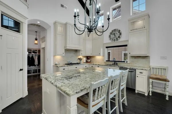 a kitchen with stainless steel appliances granite countertop a sink a stove and a wooden floor