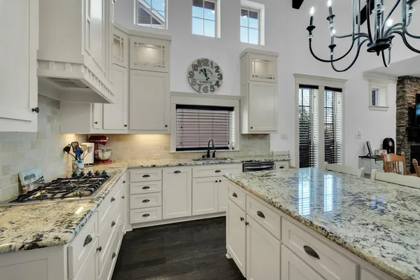a kitchen with stainless steel appliances granite countertop a sink stove and cabinets