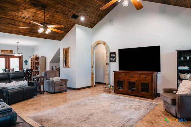 a living room with furniture a flat screen tv and a fireplace