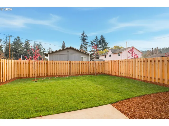 a view of a backyard with wooden fence