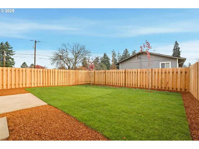 a view of a backyard with wooden fence
