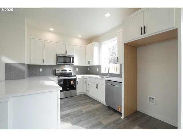 a kitchen with granite countertop white cabinets and white appliances